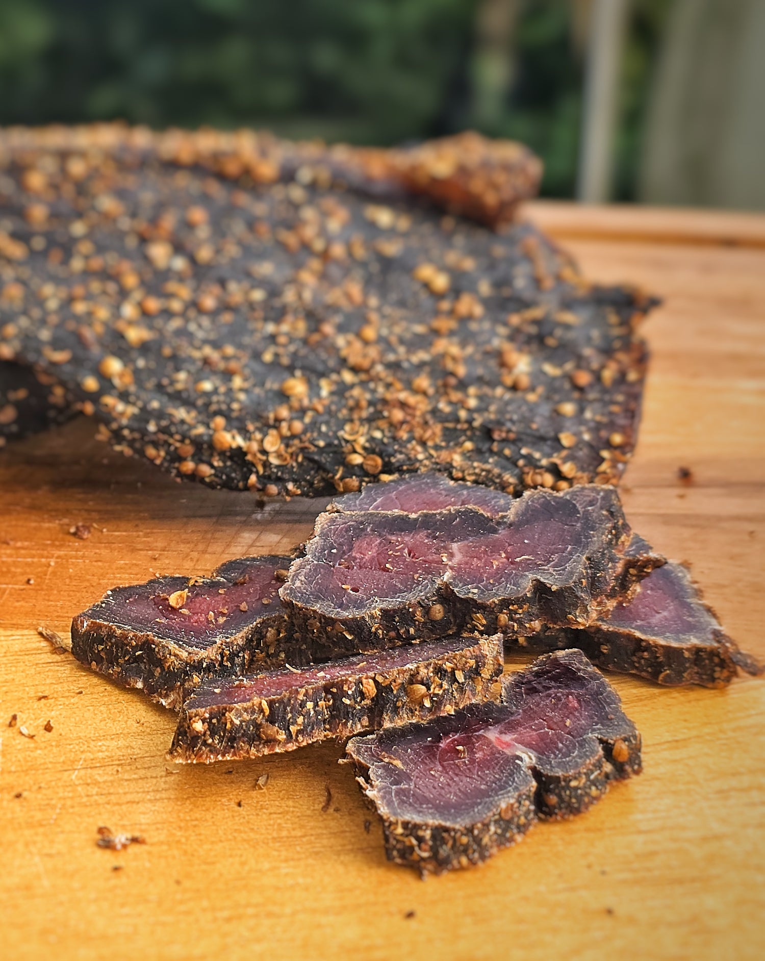 Thick sliced dried meat (Biltong) on a wooden surface
