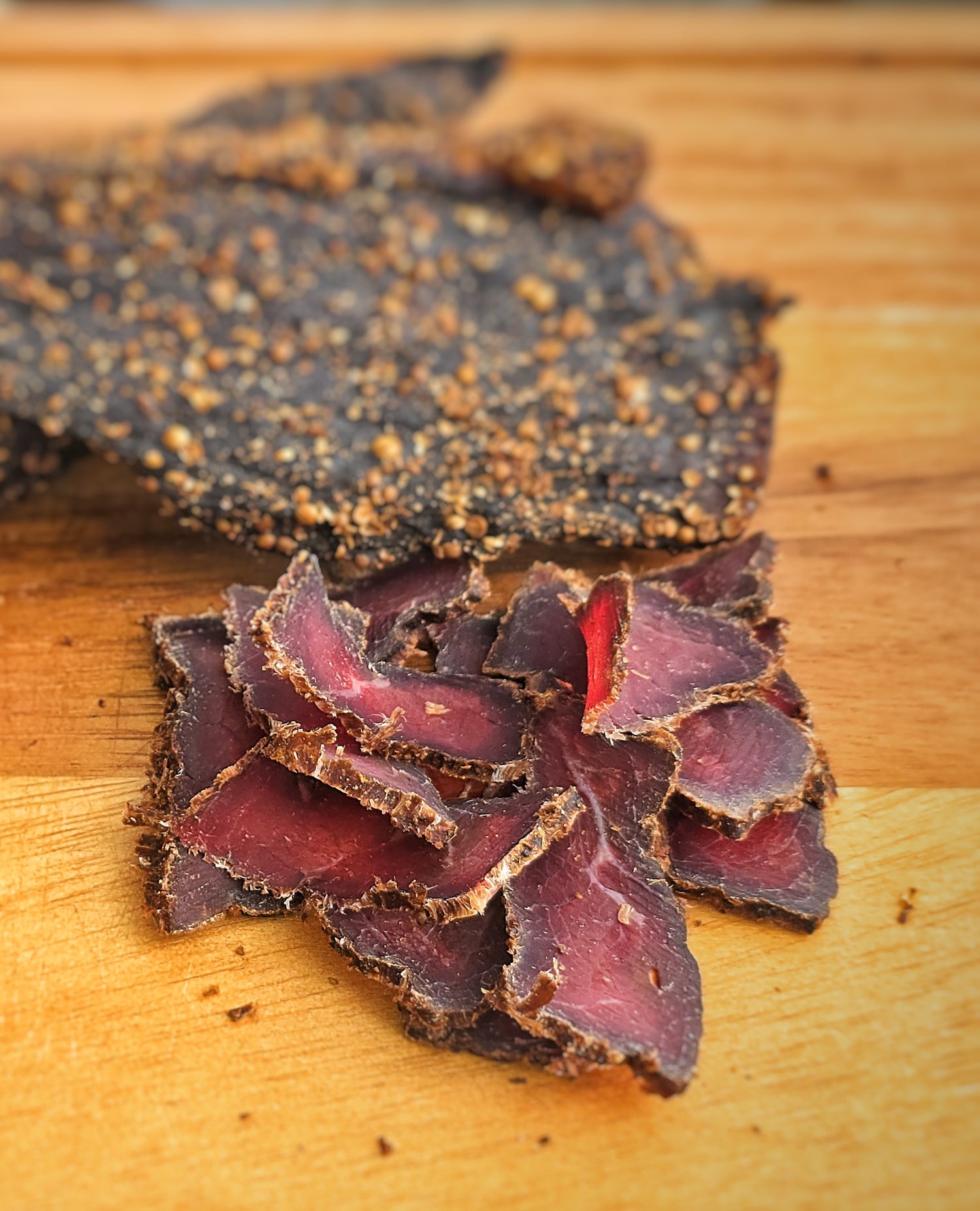Thinly sliced dried meat (Biltong) on a wooden surface
